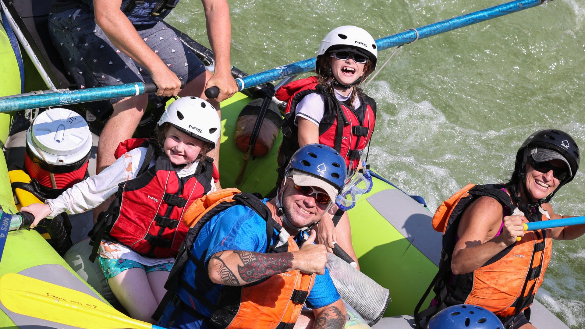 A happy family is rafting on the Alberton Gorge with Zoo Town Surfers. Dad gives a thumbs up, kids are grinning! Everyone is happy!