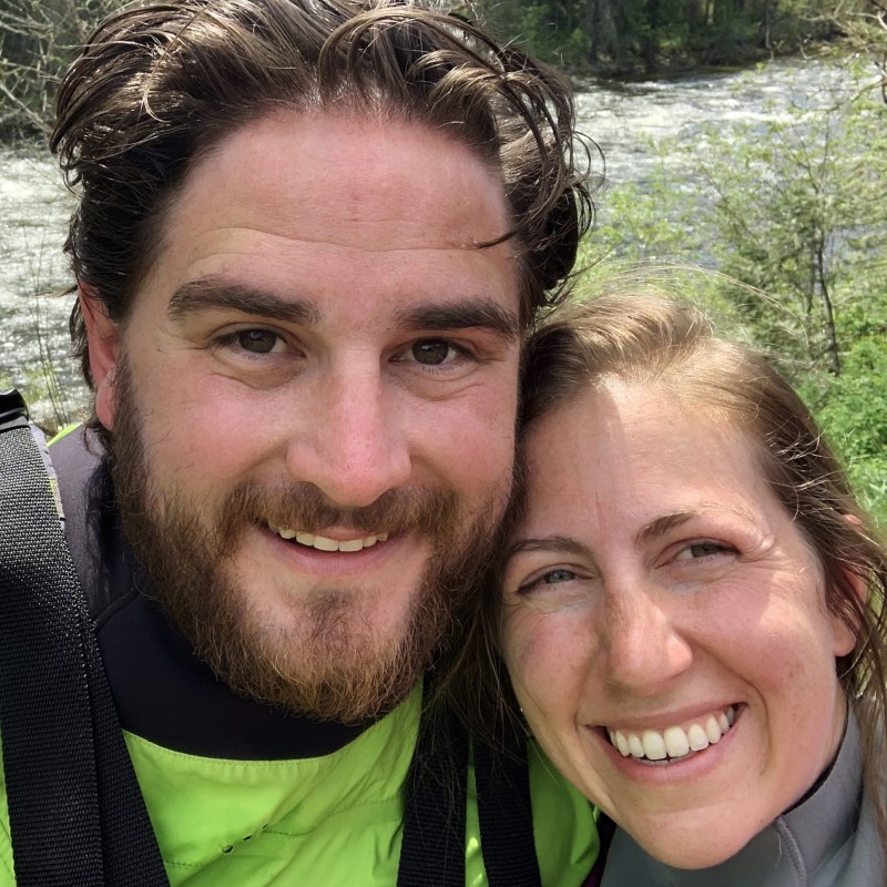 Ian and Megan the owners of Zoo Town Surfers are smiling in their drysuits with the Lochsa River in the background.